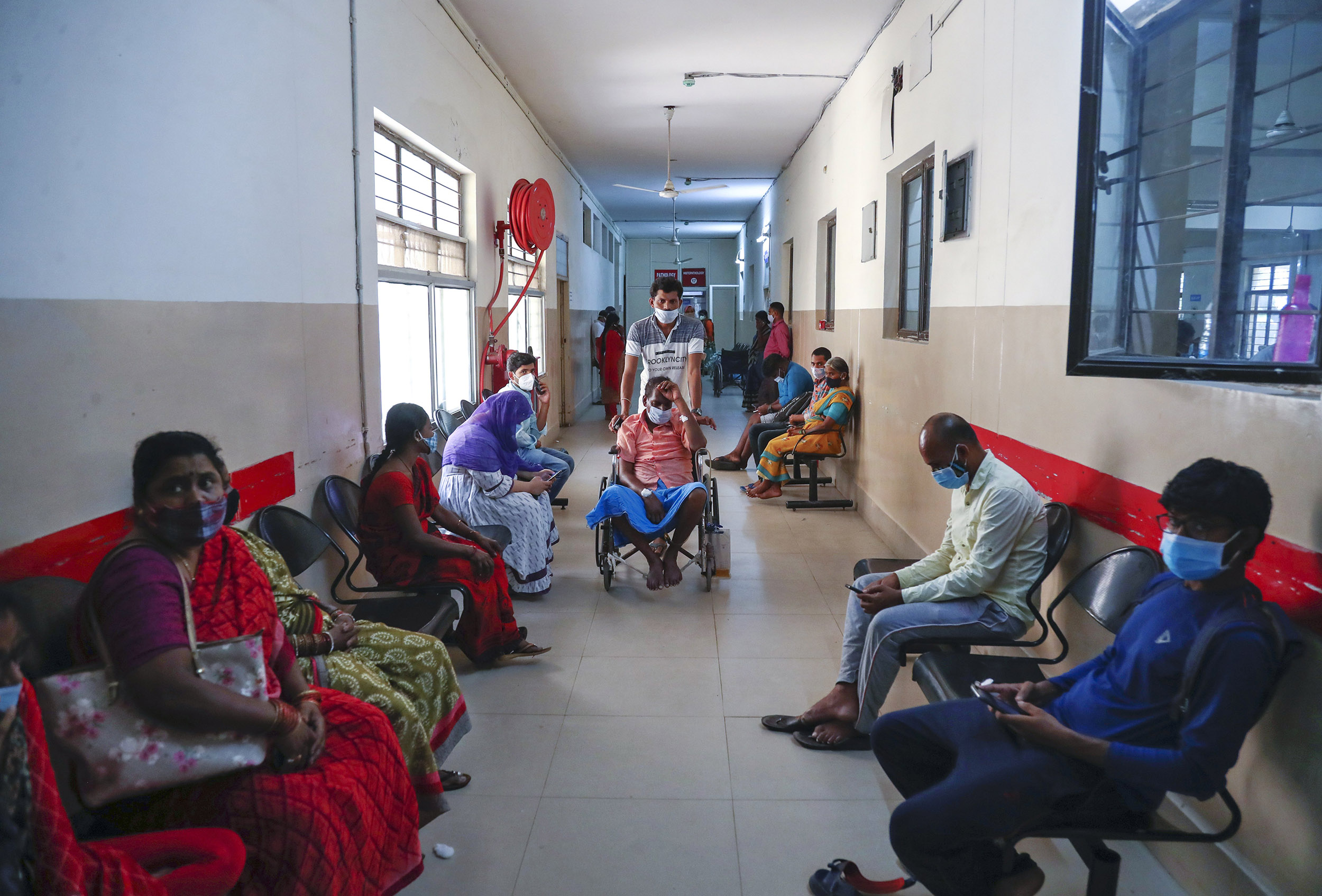 An Indian patient infected with black fungus is taken on a wheel chair for treatment at the Mucormycosis ward of a government hospital in Hyderabad, India, Sunday, May 23, 2021. (AP Photo/Mahesh Kumar A.)