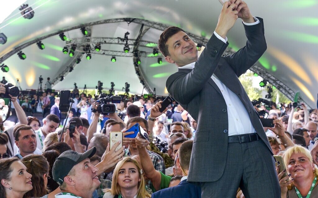 FILE - Ukrainian President Volodymyr Zelenskyy takes a selfie at the first congress of his party called Servant of the People in the city Botanical Garden, Kiev, Ukraine, June 9, 2019. (AP Photo/Zoya Shu, File)