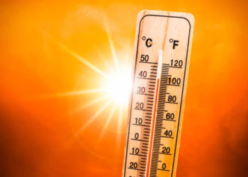 Background for a hot summer or heat wave, orange sky with with bright sun and thermometer