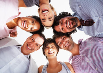 Group of smiling business people standing in huddle