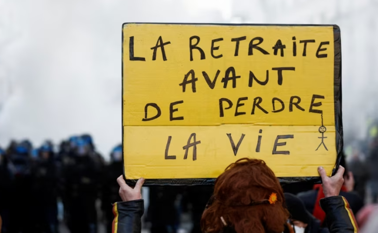 Një protestuese në Paris kundër planit qeveritar për pensione mban një pankartë ku shkruan "Pensionim para vdekjes". Francë, 21 janar 2023