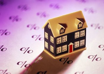 Miniature home on sheet of percent signs