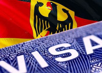 German visa document close up, 3D rendering. Passport visa on German flag. German visitor visa in passport. German multi entrance visa in passport. Close up of a Visa document and passport