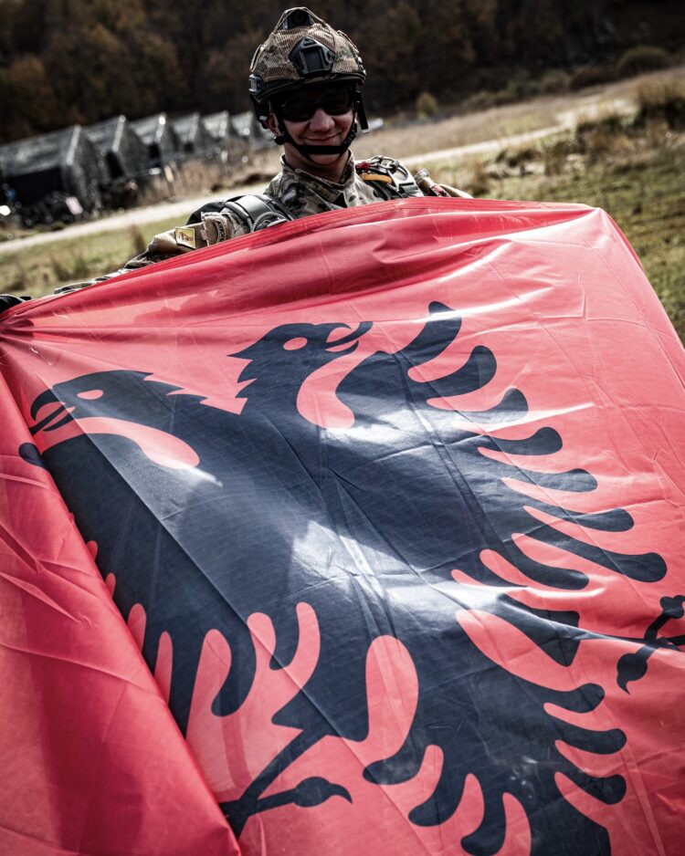 An Albanian Special Forces operator proudly displays the Albanian flag after a parachute drop. 
Exercise ‘Strong Balkan 23’ was hosted by the Albanian Armed Forces to further strengthen Allied Special Forces’ readiness and capabilities. Through joint tactical training, troops from 8 NATO countries learnt from one another’s experiences, improving their ability to work effectively together in complex operational scenarios. Scenarios involved close quarters battle, helicopter fast rope insertions and p