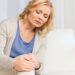 people, healthcare and problem concept - unhappy woman suffering from pain in leg at home