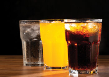 Glasses of soda flavors orange, lemon and cola.