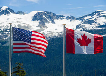 Canadian and American flags in the mountains