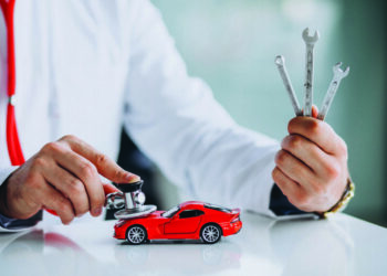 Car doctor with stethoscope in a car showroom