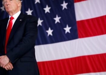 FILE PHOTO: U.S. President Donald Trump stands in front of a U.S. flag while listening to U.S. first lady Melania Trump give a speech to U.S. troops at the Naval Air Station Sigonella before returning to Washington D.C. at Sigonella Air Force Base in Sigonella, Sicily, Italy, May 27, 2017. REUTERS/Jonathan Ernst/File Photo