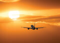 Plane is taking off at sunset.