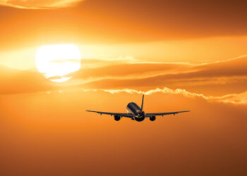 Plane is taking off at sunset.