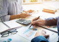 business man financial inspector and secretary making report, calculating or checking balance. Internal Revenue Service inspector checking document. Audit concept